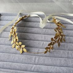 Grecian Inspired Boho Bridal Hair Accessory made with gold leaves with pearl detail and rhinestones. This piece is striking and requires minimum amount of jewelry. Perfect for the boho bride and the brides who loves to wear something unique. Features: Flexible and bendable Hand wired Color:gold Metal: Alloy Environmenttal Standard:Hypoallergenic lead nickel free When Item is in stock, it will ship between 3-5 days of ordering. Back order items or out of stock items will take upto 3-4 weeks to ship. Once item is shipped delivery will be within 14-21 working days. If express shipping is required please contact us and we can arrange express shipping. Tracking will be provided for all orders once item is shipped. If your shipping destination is not listed, please contact us for custom shipping Hair Halo, Boho Bridal Hair, Bridal Halo, Boho Leaves, Bridal Hair Accessory, Hair Jewels, Bridal Hair Vine, Gold Leaves, Bridal Hair Pins