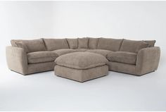 a large sectional couch with ottoman and footstool in the corner on a white background