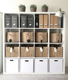 a white bookcase filled with lots of boxes and bins