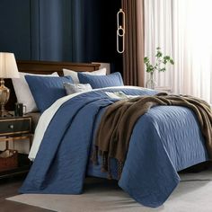 a bed with blue sheets and pillows in a room