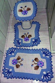 three crocheted rugs on the floor with flowers and leaves in blue colors