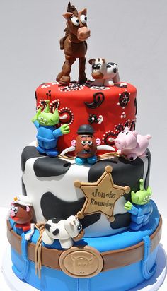 a three tiered cake decorated with farm animals and stars on it's sides