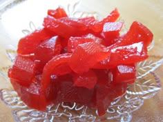 some red gummy bears are in a glass bowl