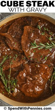 beef steaks with gravy in a skillet on top of a table