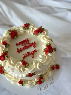 a birthday cake with white frosting and red roses