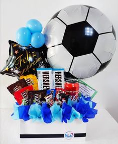 a soccer ball, balloon and snacks in a gift box