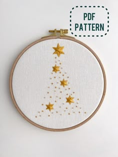 a cross stitch christmas tree with gold stars on it and the words pof pattern above it