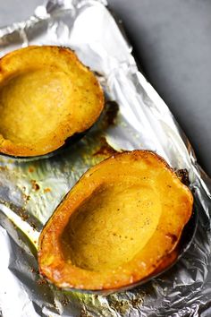 two baked sweet potatoes sitting on top of aluminum foil