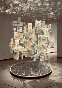 an art installation with multiple pieces of paper hanging from the ceiling