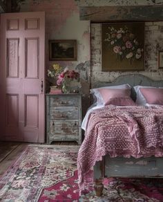 a bed with pink sheets and pillows in a bedroom