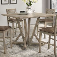 a dining table with chairs and a vase filled with flowers on top of the table