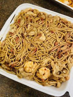 a white tray filled with noodles and meat