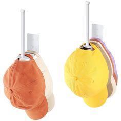 two hats hanging from hooks on the side of a hat rack, one in orange and one in yellow