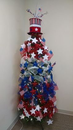 a decorated christmas tree with red, white and blue decorations in the shape of an american flag