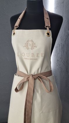 a white apron with a brown ribbon on it