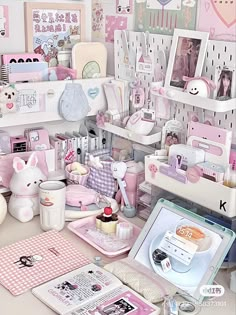 a room filled with lots of pink items and pictures on the wall above it is a desk full of stuff