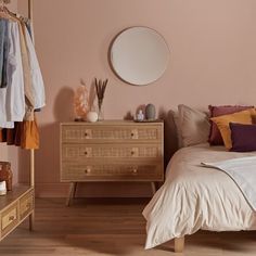 a bedroom with a bed, dresser and mirror on the wall next to each other