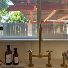 a kitchen sink with two faucets and soap dispensers next to it