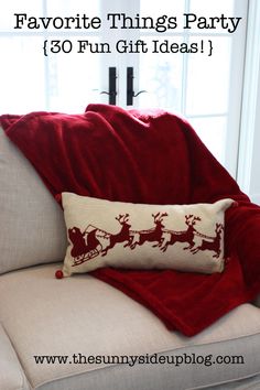 a white couch with a red pillow on top of it next to a christmas tree