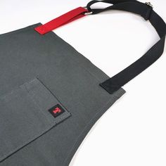 HAI kitchen or living room apron  Created to enjoy unique moments. The word HAI comes from Japanese and its meaning is ashes. This is what stands out most in this apron, its ash gray color, which makes this garment a sober and elegant accessory. It also has those red details that give it that rogue touch. In addition to being an aesthetic detail, it is functional. The only thing missing from this apron is your embroidered name. Characteristics  Unisex  30% polyester and 70% cotton fabric, 230-24 Red Details