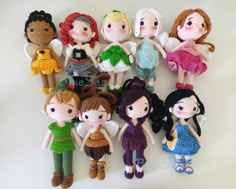 a group of crocheted dolls sitting next to each other on a white surface