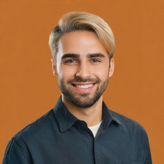 a man with a goatee smiles at the camera while standing in front of an orange background