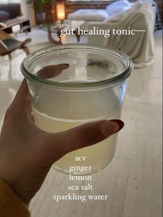 a person holding a jar of water in their hand with the caption that reads, get healing tonic acy ginger lemon sea salt sparkling water