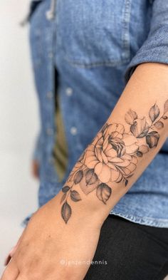 a woman's arm with a flower tattoo on the left side of her arm