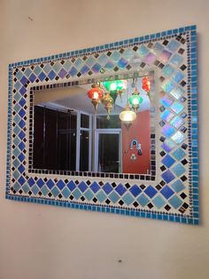 a blue and white mirror hanging on the side of a wall