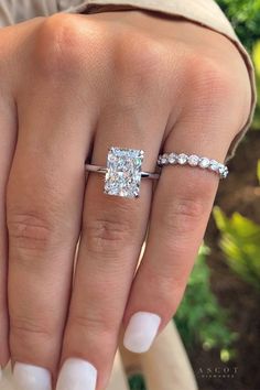 a woman's hand with two engagement rings on it