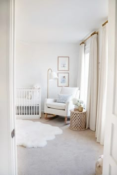 a baby's room with a white crib, rocking chair and rug on the floor