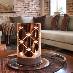 a table with a lamp on top of it in front of a couch and coffee table