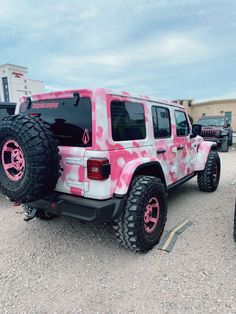 a pink and white jeep parked in a parking lot