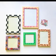 four different colored frames sitting on top of a white table next to an animal sticker