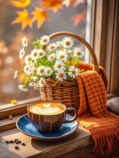 a cup of coffee sitting on top of a window sill next to a basket filled with flowers