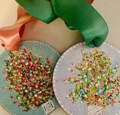 two paper plates with colorful sprinkles on them and one has a green ribbon