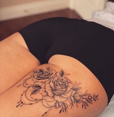 a woman laying on top of a bed with a tattoo on her stomach and legs