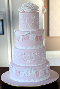 a three tiered wedding cake sitting on top of a table