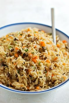 a bowl filled with rice and carrots on top of a table