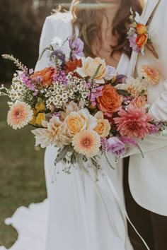 a bride and groom holding a bouquet of flowers