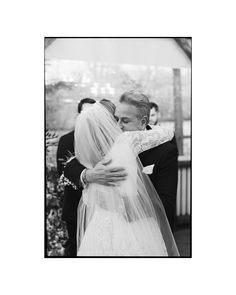 black and white photograph of bride hugging her father at the end of their wedding ceremony