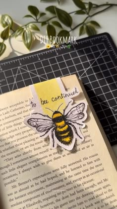 an open book with a bee on it