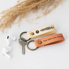 two keys are sitting next to each other on a keychain with an orange leather strap