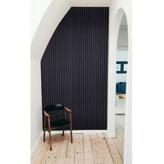 a chair sitting on top of a wooden floor next to a wall with vertical blinds