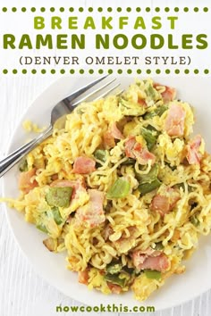 a white plate topped with pasta covered in ham and green vegetables next to a fork