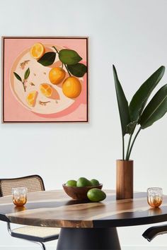 a table with some fruit on it and a potted plant in front of it