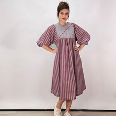 Lightweight, poly/cotton blend midi house dress from the late 70s or early 80s. Muted red and gray stripes, vertical and horizontal. Asymmetrical button from yoke closure at the bodice. Half-length large puff/balloon sleeves. Fits oversized, you can belt it if you choose. Size tag 12, fits like an XL. Shown on a M.  Find more vintage 70s here: https://etsy.me/3yr4hSB More vintage dresses here: https://etsy.me/3o83OA9 #6 Striped Cotton Midi Dress Knee-length, 80s House, Muted Red, Robes Vintage, Gray Stripes, House Dress, Red And Grey, Balloon Sleeves, Dress Red