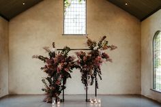 two tall vases filled with flowers on top of a floor