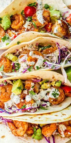 three shrimp tacos with lettuce and tomatoes