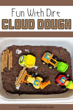 a tray filled with dirt and toys in the shape of cars on top of it